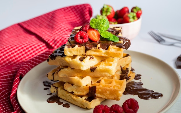 delicious belgian waffles for breakfast with strawberries and raspberries and chocolate