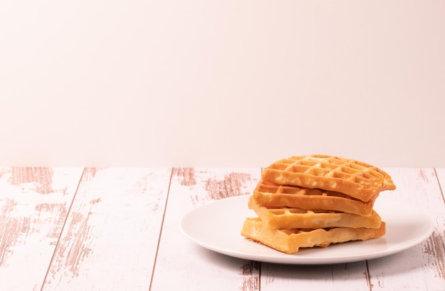 Delicious Belgian waffles served on white plate and wooden background rustic concept space for textxA