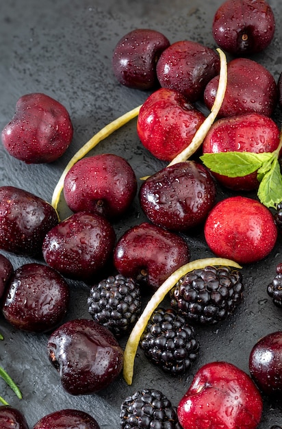 Delicious berries, red cherries, pillory, blackberry, lemon and mint leaves.