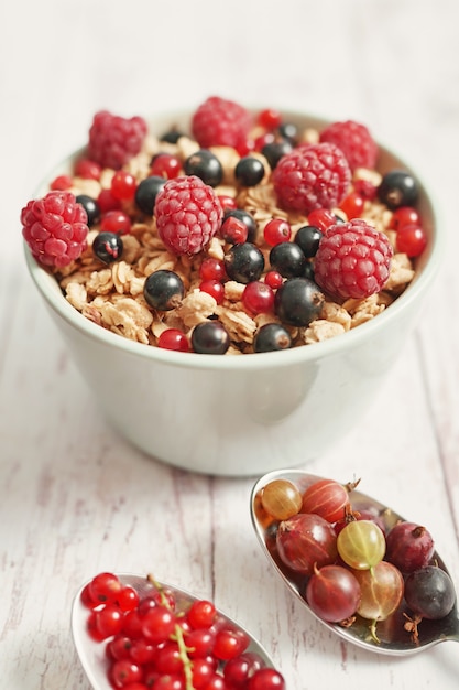 Delicious berries in a white cup and spoons