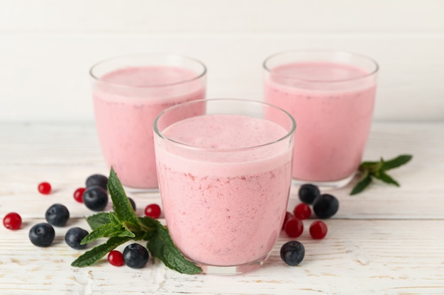 Delicious berry milkshakes on wooden table