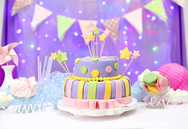 Delicious birthday cake on shiny purple background