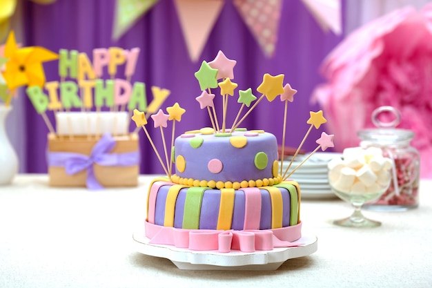 Delicious birthday cake on table on bright background