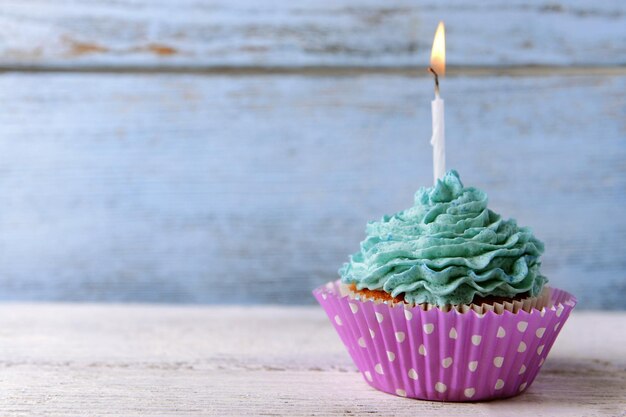 Photo delicious birthday cupcake on table on wooden background