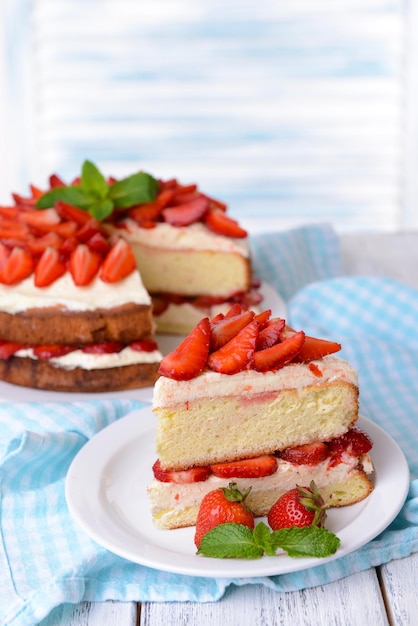 Delicious biscuit cake with strawberries on table on light background