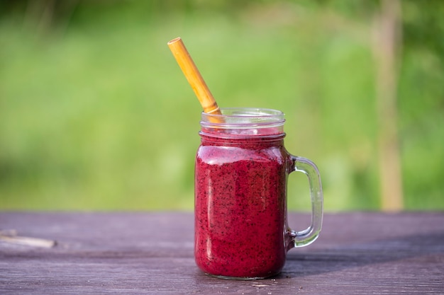 Delicious blueberry smoothie in a glass mug on the table, close up