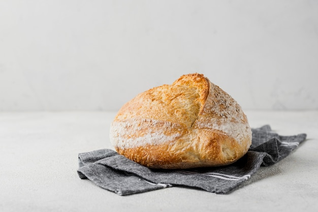 Delicious bread with flour on blue cloth