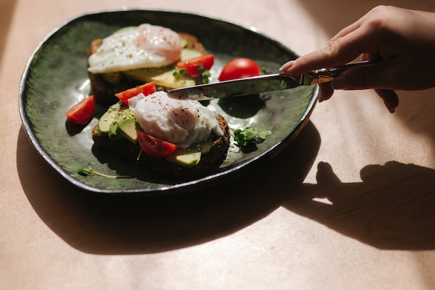 Delicious breakfast at home. Sandwich with fresh sliced avocado above rye toasted bread with cherry