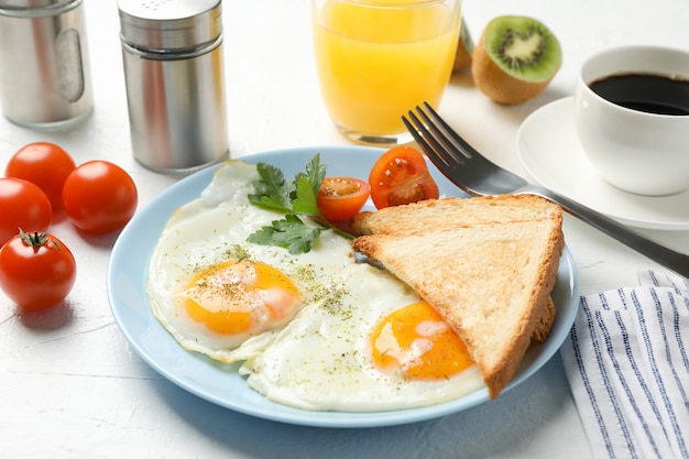 Delicious breakfast or lunch with fried eggs on white table, close up