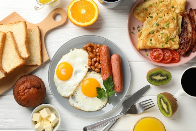 Delicious breakfast or lunch with fried eggs on white wooden surface, top view