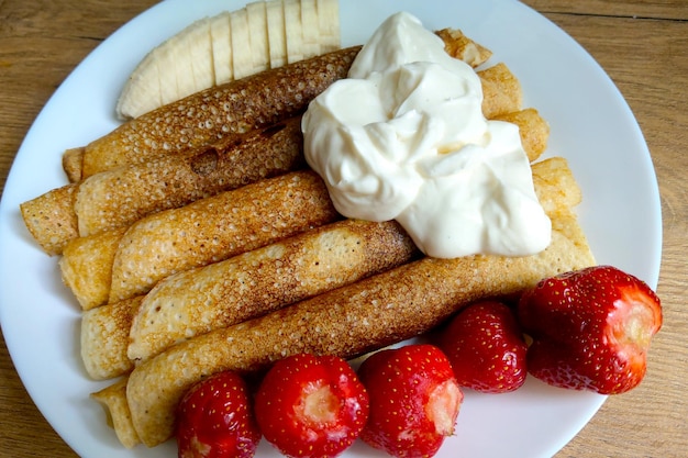 Delicious breakfast of pancakes and cream with fruits