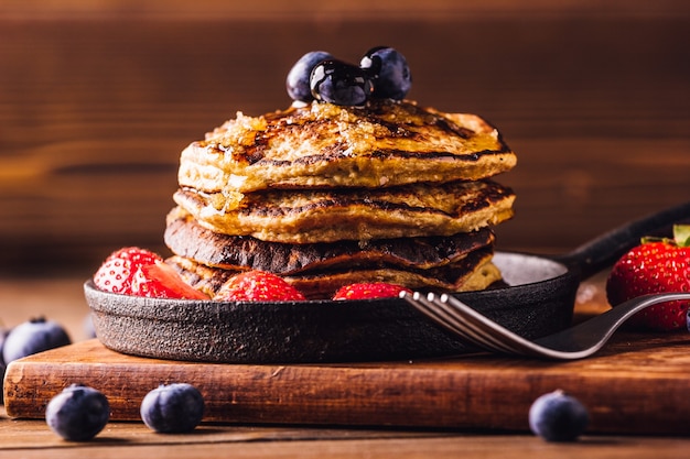 Delicious breakfast of pancakes served with strawberries and blueberries