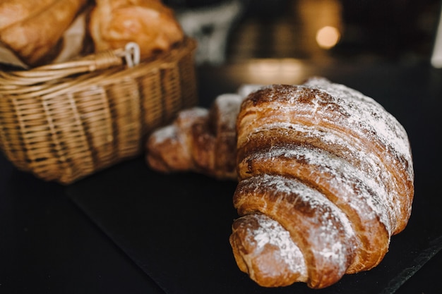 Delicious breakfast with fresh croissants on a black background, delicious baking top view copy space for text