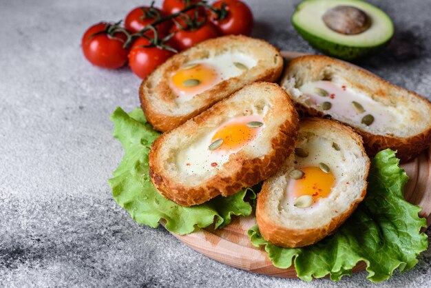 Delicious breakfast with grunts, eggs, avocado and cherry tomatoes. Pleasant morning meal with fresh sandwiches