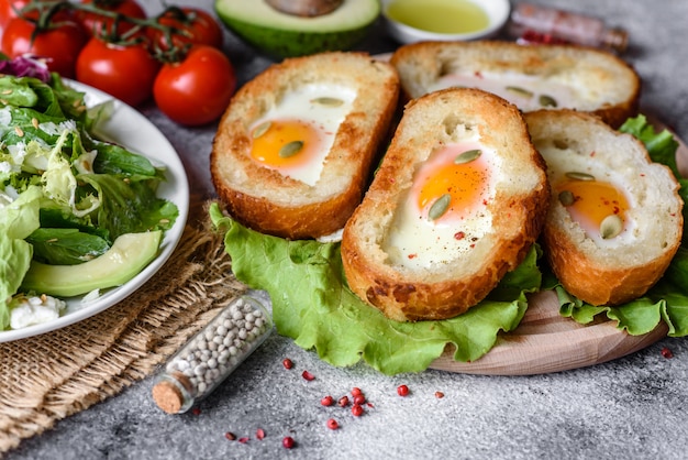 Delicious breakfast with grunts, eggs, avocado and cherry tomatoes. Pleasant morning meal with fresh sandwiches