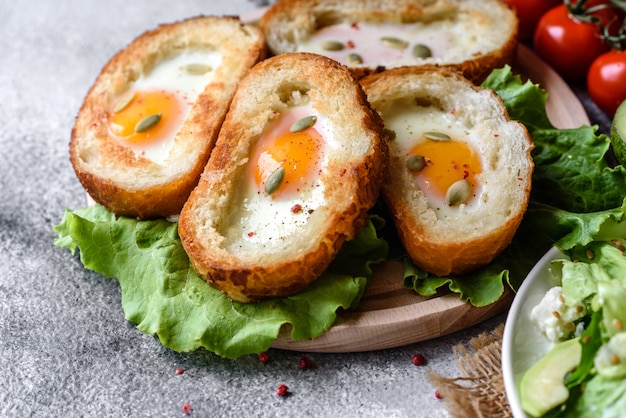 Delicious breakfast with grunts, eggs, avocado and cherry tomatoes. Pleasant morning meal with fresh sandwiches