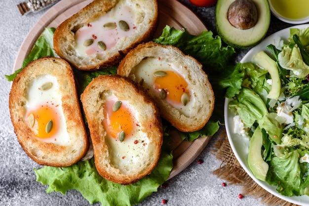 Delicious breakfast with grunts, eggs, avocado and cherry tomatoes. Pleasant morning meal with fresh sandwiches