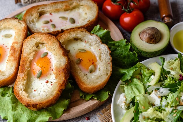 Delicious breakfast with grunts, eggs, avocado and cherry tomatoes. Pleasant morning meal with fresh sandwiches