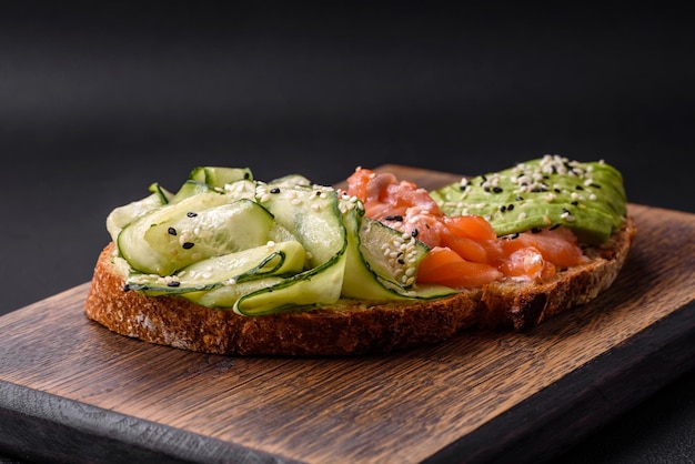 Delicious brown bread toast with salmon avocado cucumber and sesame seeds