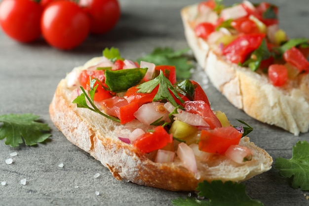 Delicious bruschetta snacks on gray textured background