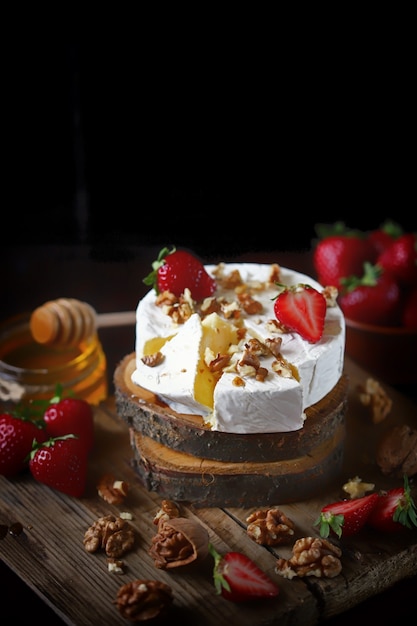 Delicious camembert cheese with honey, nuts and strawberries