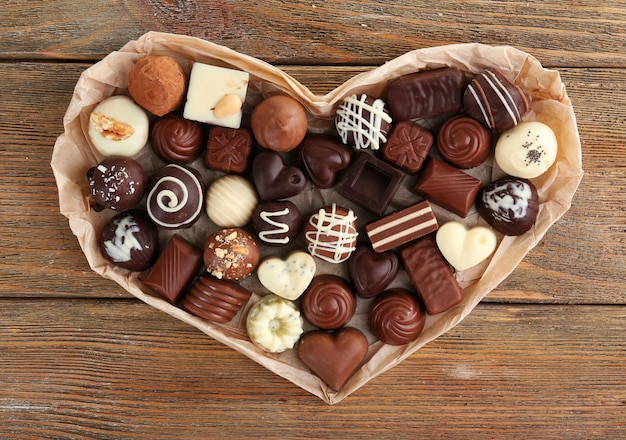 Delicious chocolate candies on wooden background