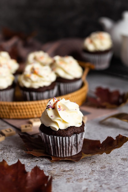 Delicious chocolate cupcake with a cream cap and orange sprinkles