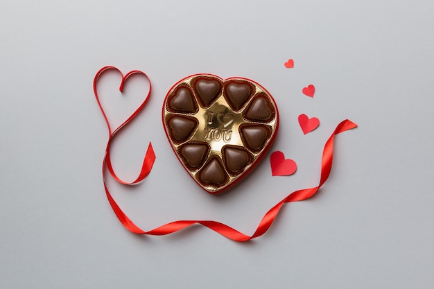 Delicious chocolate pralines in red box for Valentine's Day Heart shaped box of chocolates top view with copy space