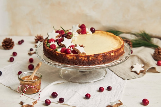 Delicious Christmas cheesecake with cranberries and cookies stars on a white table