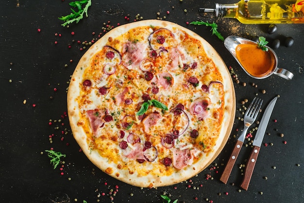 Delicious classic meat pizza on black background