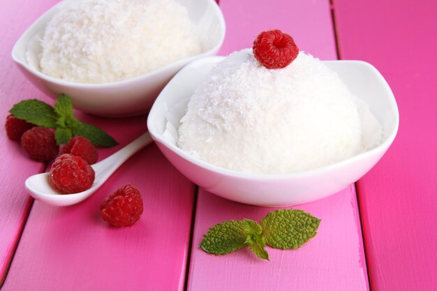 Delicious coconut cakes in bowls on table closeup