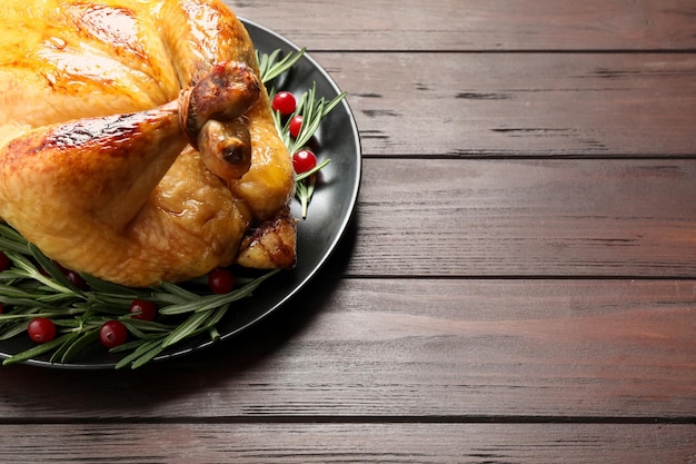 Delicious cooked turkey served on wooden table closeup with space for text Thanksgiving Day celebration