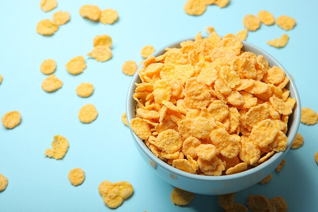 Delicious cornflakes in a plate against colored background