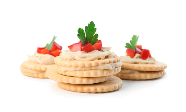 Delicious crackers with humus bell pepper and parsley on white background