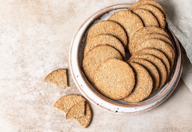 Delicious crackers with sesame and flax seeds on brown background Healthy snack