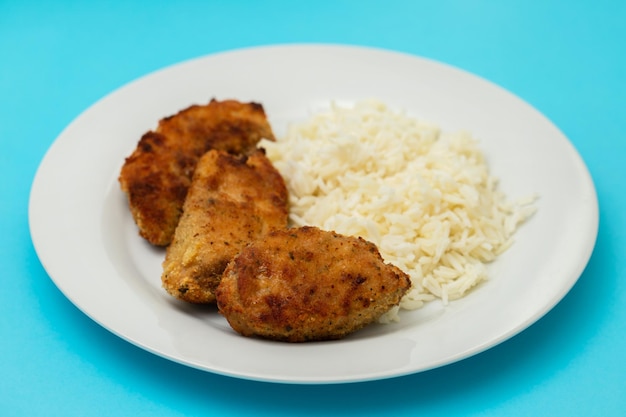 Delicious crispy fried breaded chicken breast strips with boiled rice