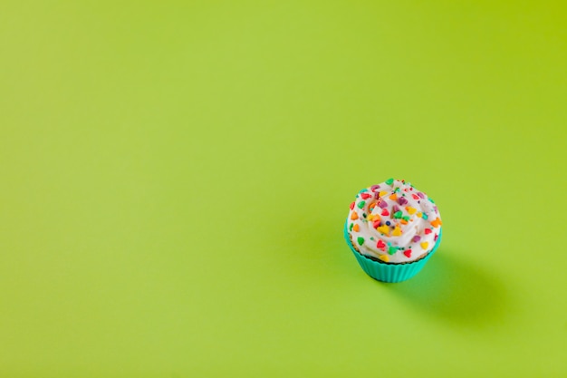 Delicious cupcake on green background