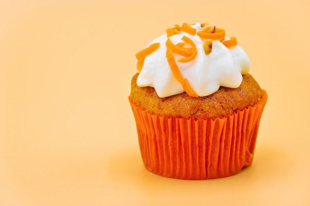 Delicious cupcake on orange pastel color background.