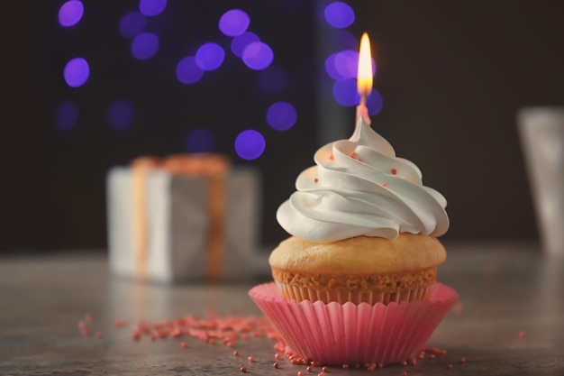 Delicious cupcake with candle on blurred background