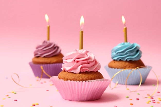 Delicious cupcake with a candle on a colored background with space to insert text. Festive background, birthday. High quality photo