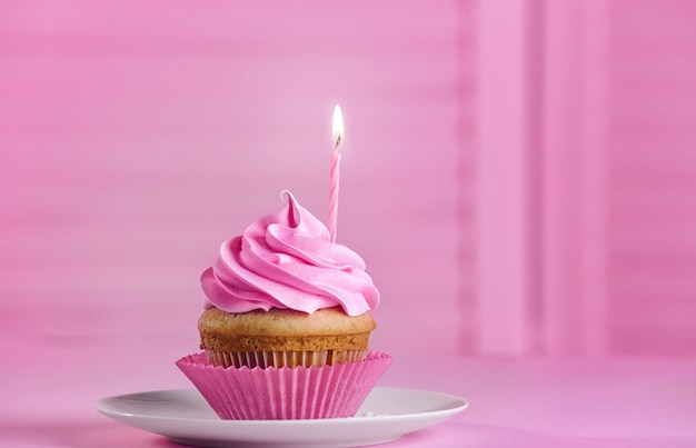 Delicious cupcake with candle on table