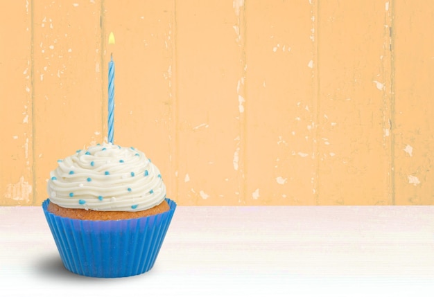 Delicious cupcake with cream on background