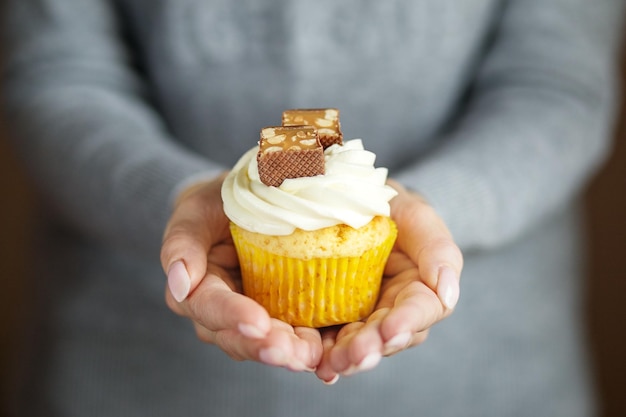 Delicious cupcake with cream and candy in the hands Copy space Concept for food desserts bakery celebration birthday