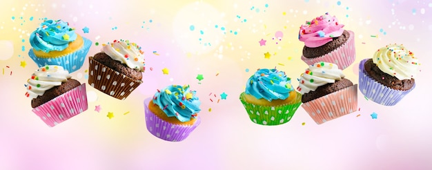 Delicious Cupcakes for party, birthday. Various cupcakes with pink white and blue cream flying over pink abstract background