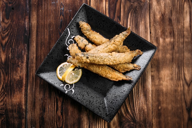 Delicious deep-fried capelin with in a black plate