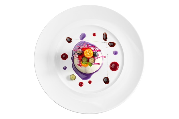 Delicious dessert - vanilla mousse with berry filling and caramel and berry decoration in a white plate. Isolated on white surface. View from above