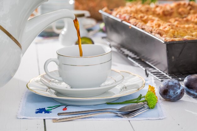 Delicious dessert with plum cake and coffee in the countryside