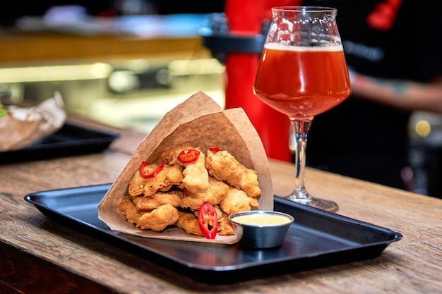 Delicious dinner nuggets in restaurant on a wooden table. Tasty food with beer in cafe or pub menu the bar counter.