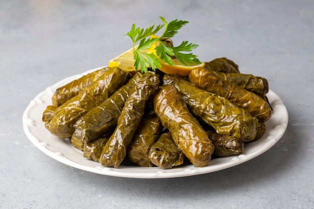 Delicious dolma sarma stuffed grape leaves rice white yogurt sauce Lebanese dolma sarma on plate Lebanon turkish greek middle eastern cuisine Turkish name Yaprak sarma