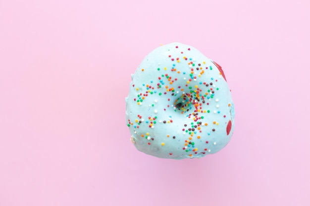 Delicious donut on color pink background